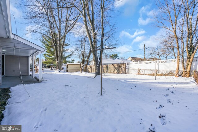 yard covered in snow with a carport