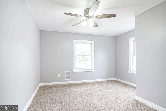 carpeted spare room featuring ceiling fan