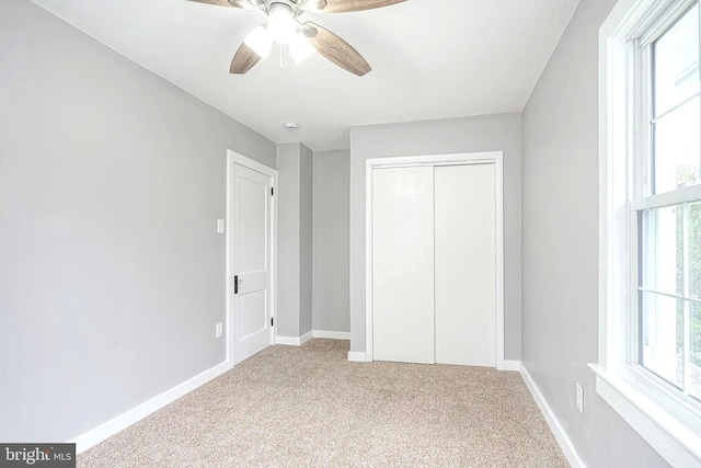 unfurnished bedroom with carpet flooring, ceiling fan, and a closet