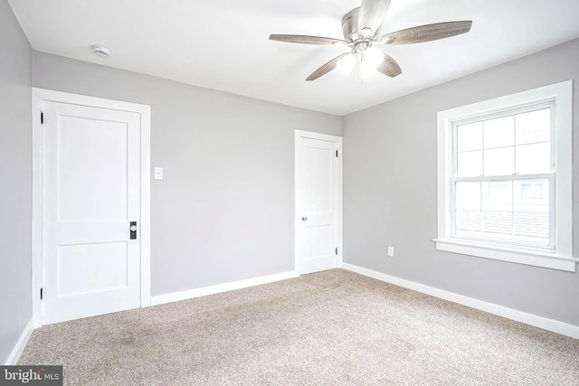 carpeted empty room featuring ceiling fan