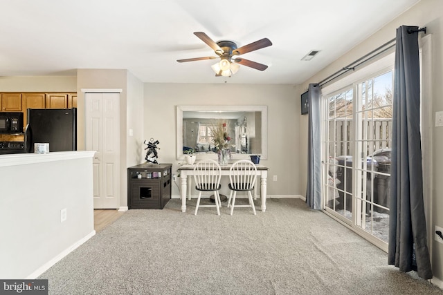 dining area featuring light carpet and ceiling fan