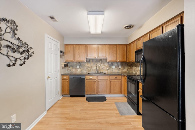 kitchen with sink, backsplash, light hardwood / wood-style flooring, and black appliances