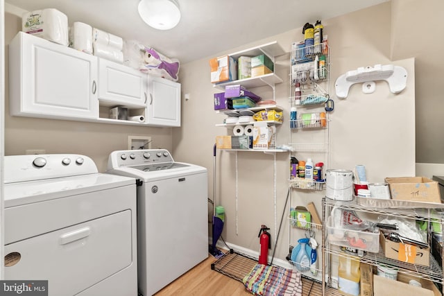 washroom featuring cabinets, independent washer and dryer, and light hardwood / wood-style floors