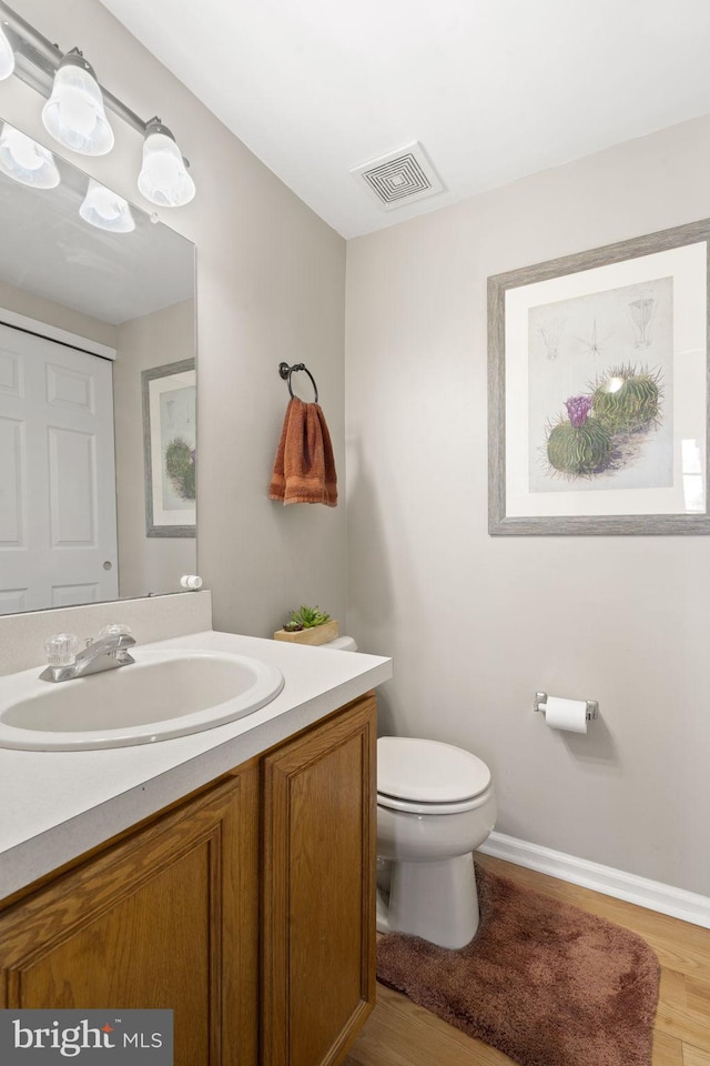 bathroom with vanity, wood-type flooring, and toilet