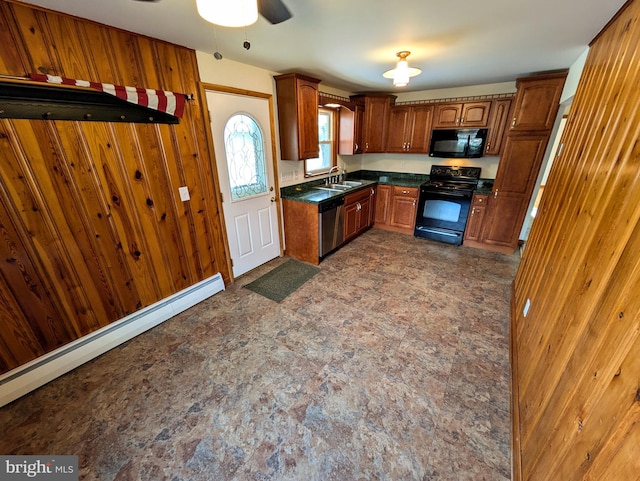 kitchen featuring ceiling fan, sink, a baseboard radiator, wood walls, and black appliances