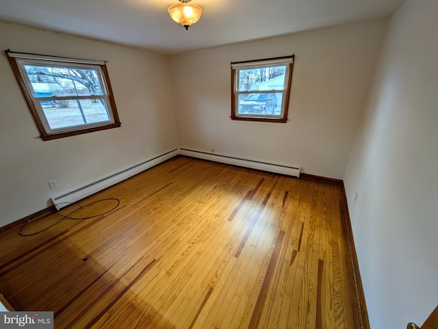 spare room featuring wood-type flooring and a baseboard radiator