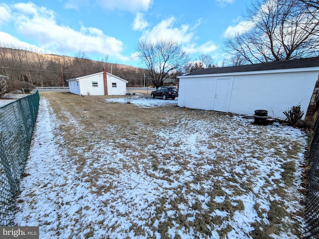 yard covered in snow featuring an outdoor structure