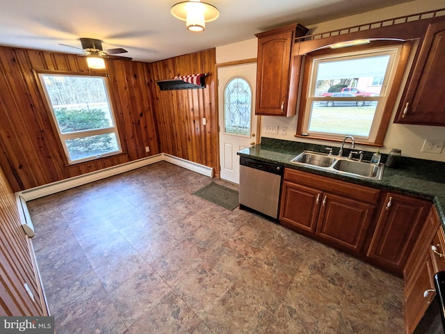 kitchen featuring wood walls, dishwasher, ceiling fan, and sink