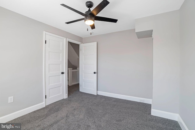 unfurnished bedroom with ceiling fan and dark carpet