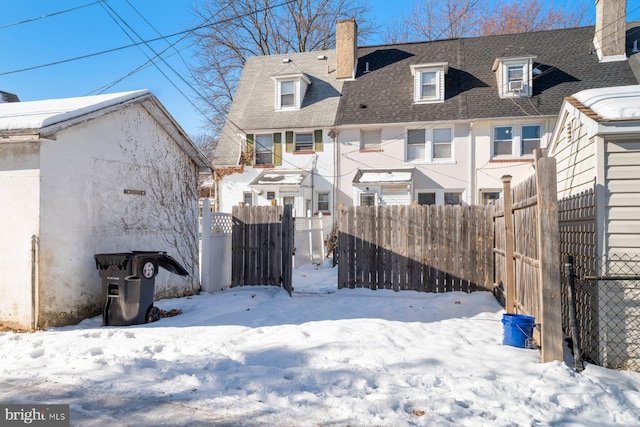 view of snow covered back of property