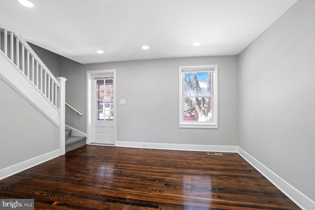 entrance foyer with dark hardwood / wood-style flooring and a healthy amount of sunlight