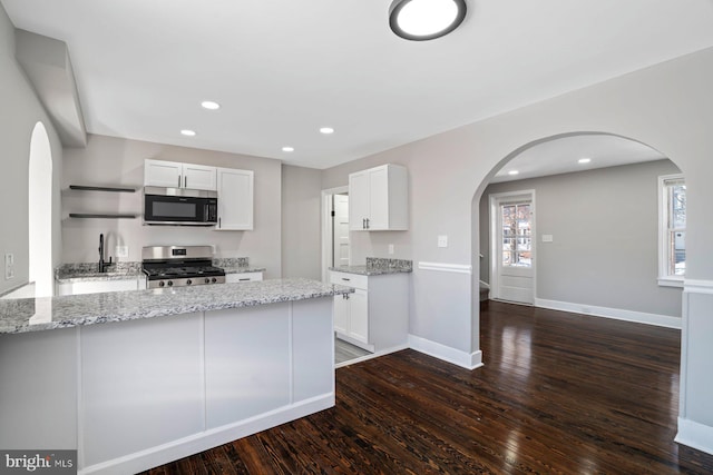 kitchen with light stone countertops, white cabinets, and stainless steel appliances