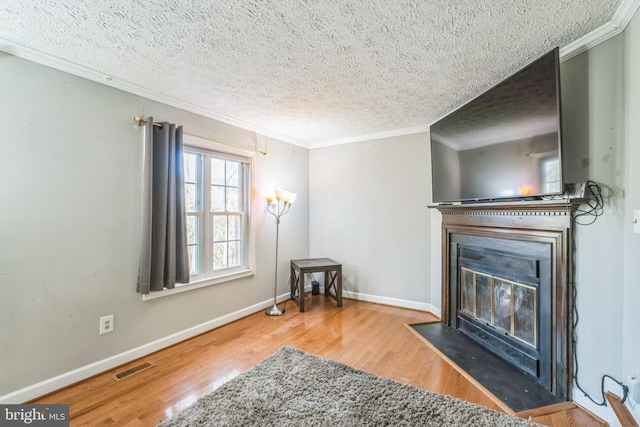 living room featuring crown molding, hardwood / wood-style floors, and a textured ceiling