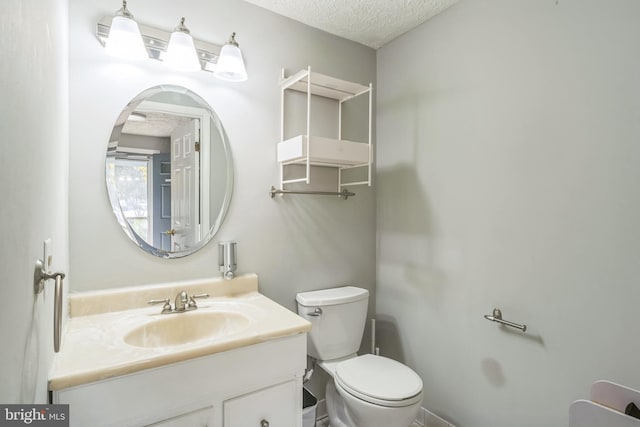 bathroom featuring vanity, a textured ceiling, and toilet