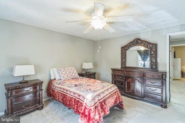 bedroom with ceiling fan, light carpet, and a textured ceiling