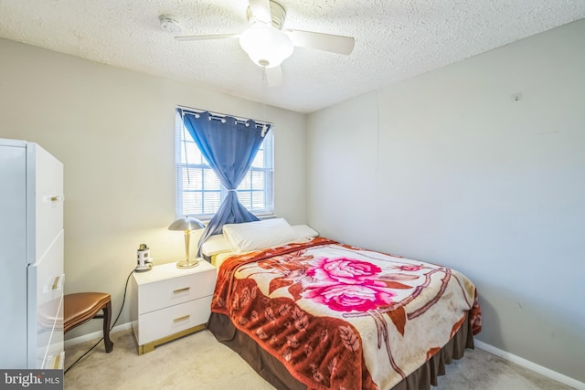 carpeted bedroom featuring a textured ceiling, white refrigerator, and ceiling fan