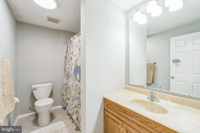 bathroom featuring tile patterned flooring, vanity, toilet, and a textured ceiling