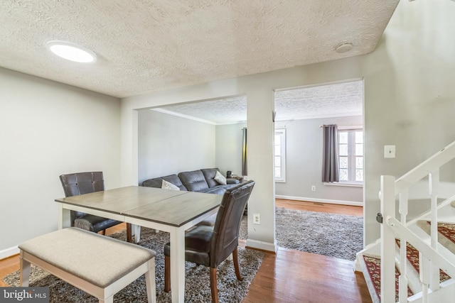 dining room with hardwood / wood-style flooring and a textured ceiling