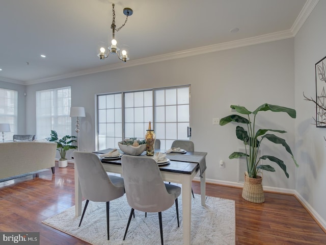 dining area featuring crown molding, dark hardwood / wood-style floors, and an inviting chandelier