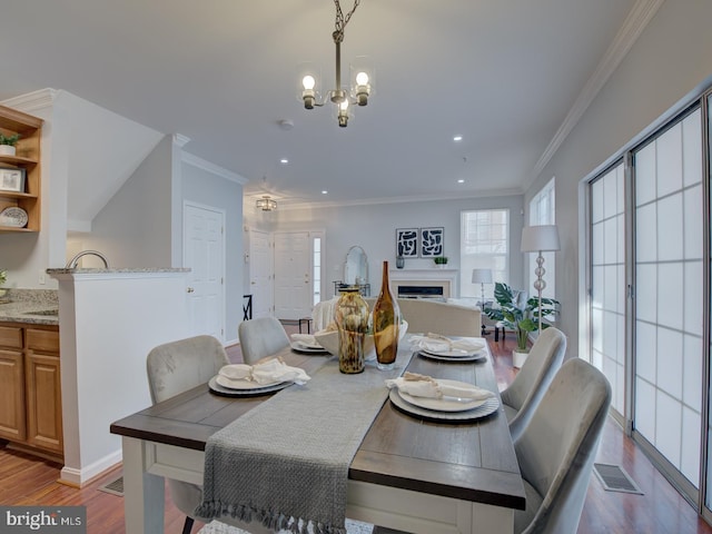 dining space featuring a notable chandelier, wood-type flooring, and crown molding