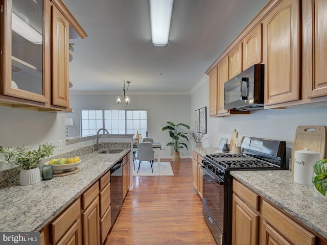 kitchen featuring crown molding, sink, black appliances, pendant lighting, and a chandelier