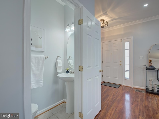 foyer entrance with hardwood / wood-style flooring and ornamental molding