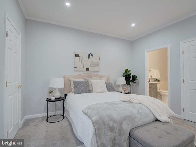 carpeted bedroom with ornamental molding and connected bathroom