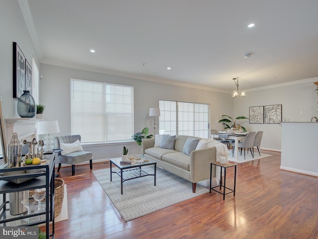 living room with crown molding, hardwood / wood-style floors, and an inviting chandelier