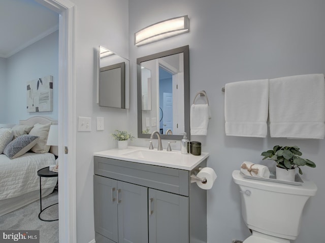 bathroom with vanity, toilet, and crown molding