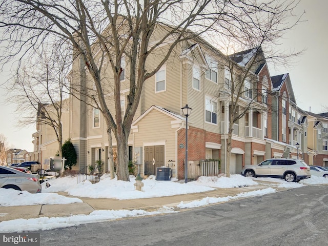 snow covered property with central air condition unit