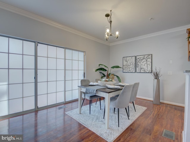 dining area featuring dark wood-type flooring, an inviting chandelier, and crown molding