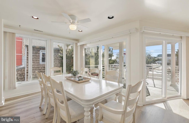 dining area featuring light wood-type flooring, ceiling fan, and a healthy amount of sunlight