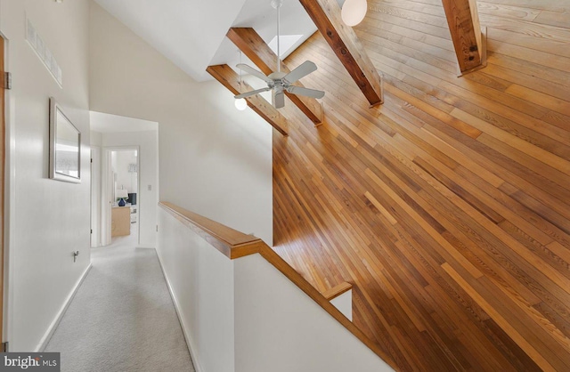 hallway with high vaulted ceiling and beamed ceiling