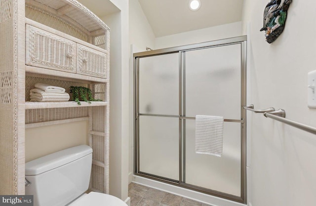 bathroom featuring a shower with shower door and toilet