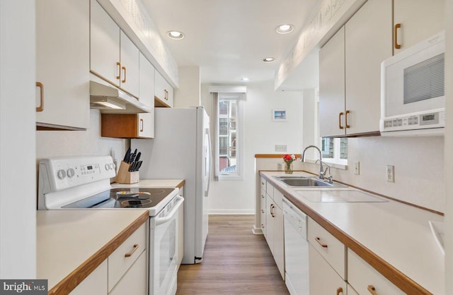 kitchen featuring white cabinetry, sink, white appliances, and light hardwood / wood-style floors