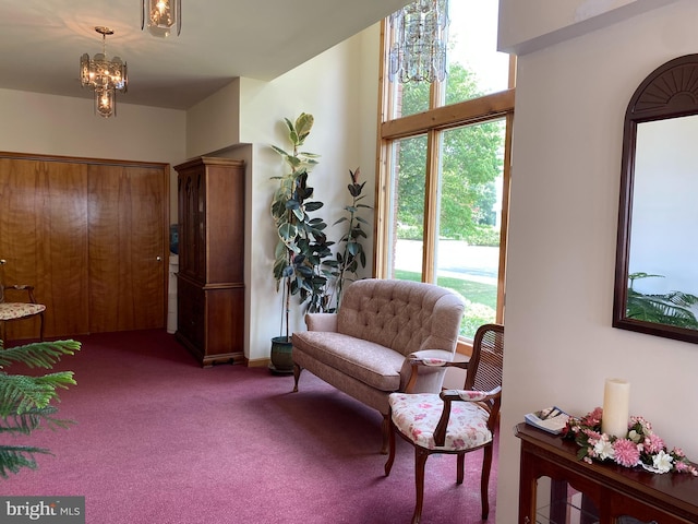 living area with carpet floors and an inviting chandelier