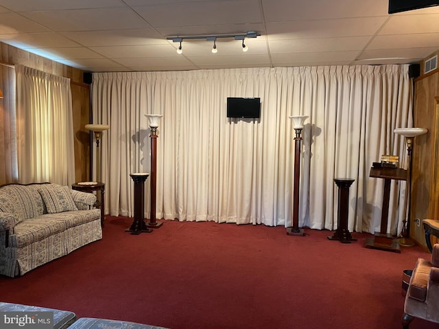 sitting room featuring wooden walls and carpet