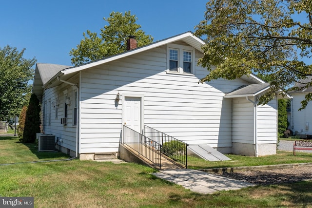 rear view of house featuring a yard and central AC