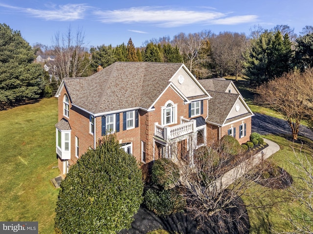 view of front of property featuring a balcony and a front yard