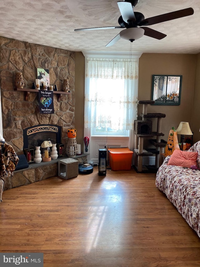 bedroom with ceiling fan, wood-type flooring, and a textured ceiling