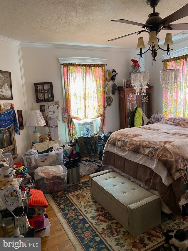 bedroom with a textured ceiling, cooling unit, wood-type flooring, and ceiling fan with notable chandelier