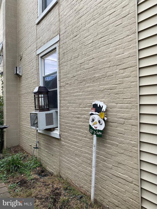 view of side of property featuring a wall mounted air conditioner and cooling unit