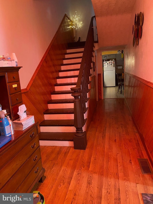 staircase with hardwood / wood-style flooring