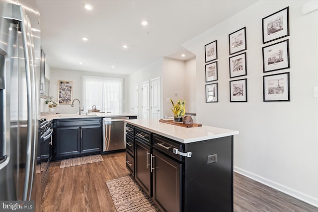 kitchen with a center island, stainless steel appliances, dark hardwood / wood-style floors, and sink