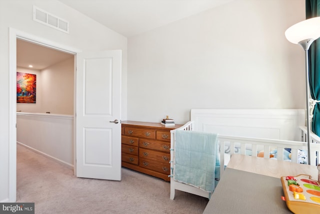 carpeted bedroom featuring a crib