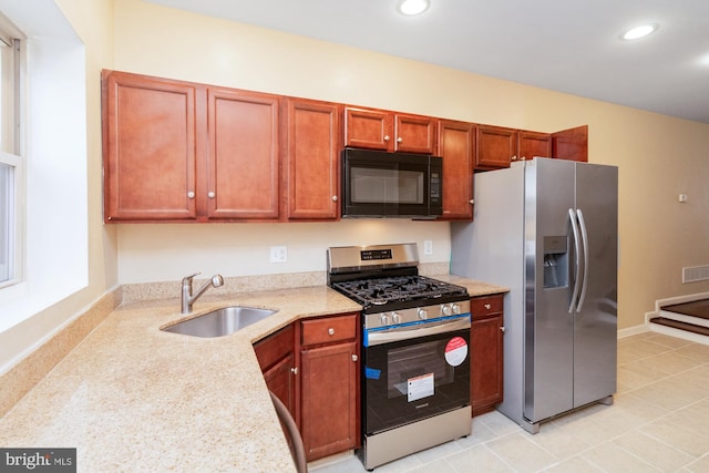 kitchen featuring light stone counters, appliances with stainless steel finishes, and sink