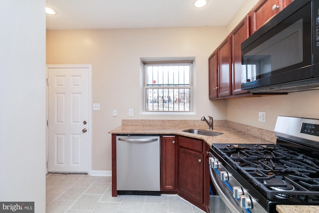 kitchen with light tile patterned flooring, appliances with stainless steel finishes, and sink