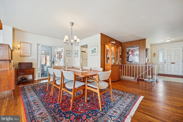 dining area featuring dark wood-type flooring and a notable chandelier