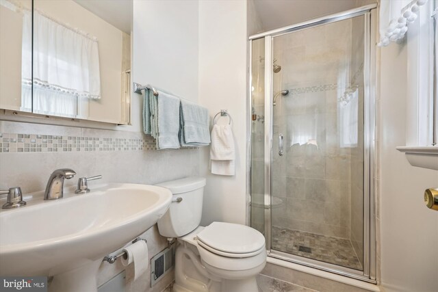 bathroom with sink, backsplash, toilet, and walk in shower