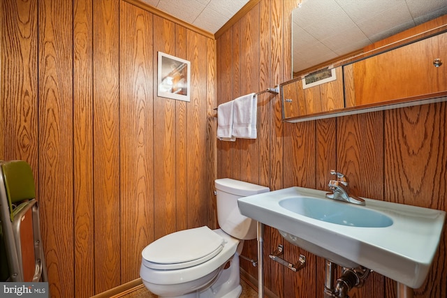 bathroom featuring toilet and wooden walls